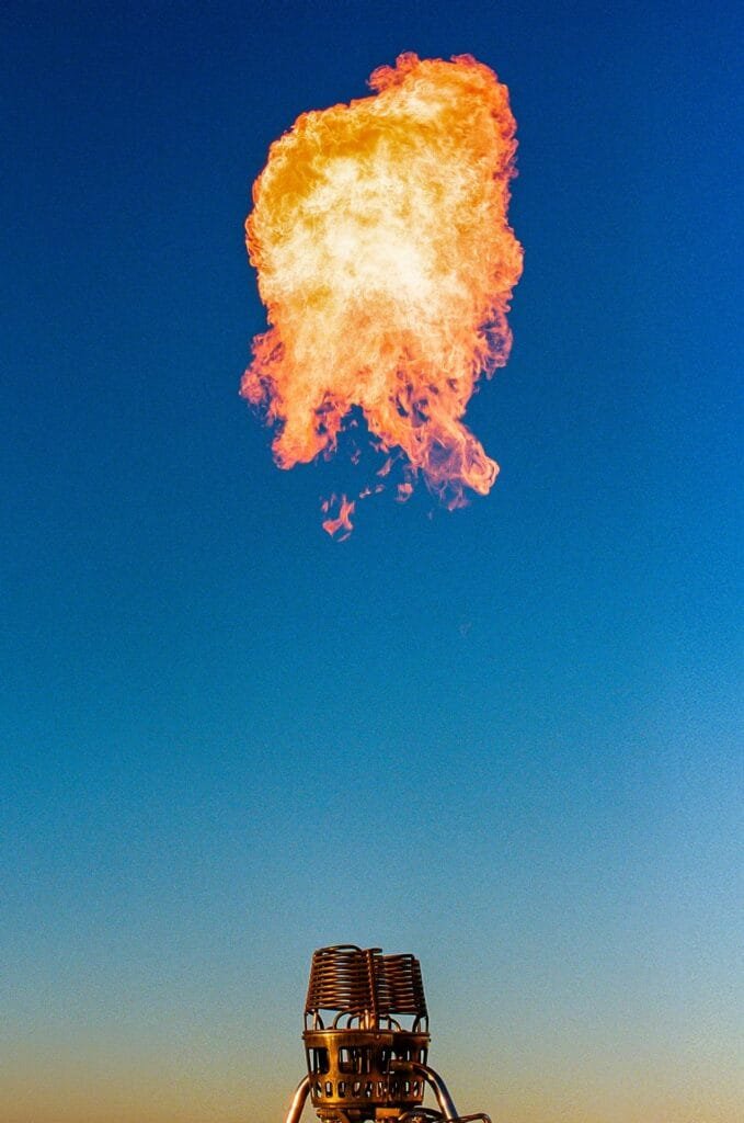 Flamme s’échappant du brûleur d’une montgolfière sur fond de ciel bleu dans le désert d’Agafay.