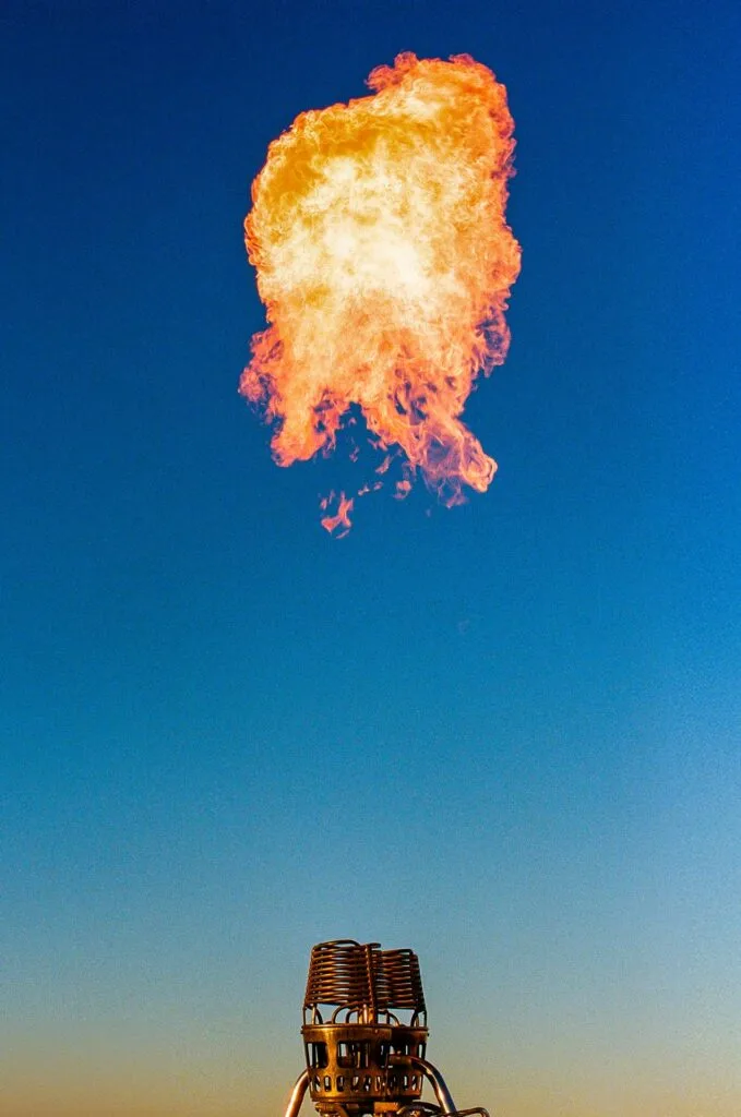 Flamme s’échappant du brûleur d’une montgolfière sur fond de ciel bleu dans le désert d’Agafay.