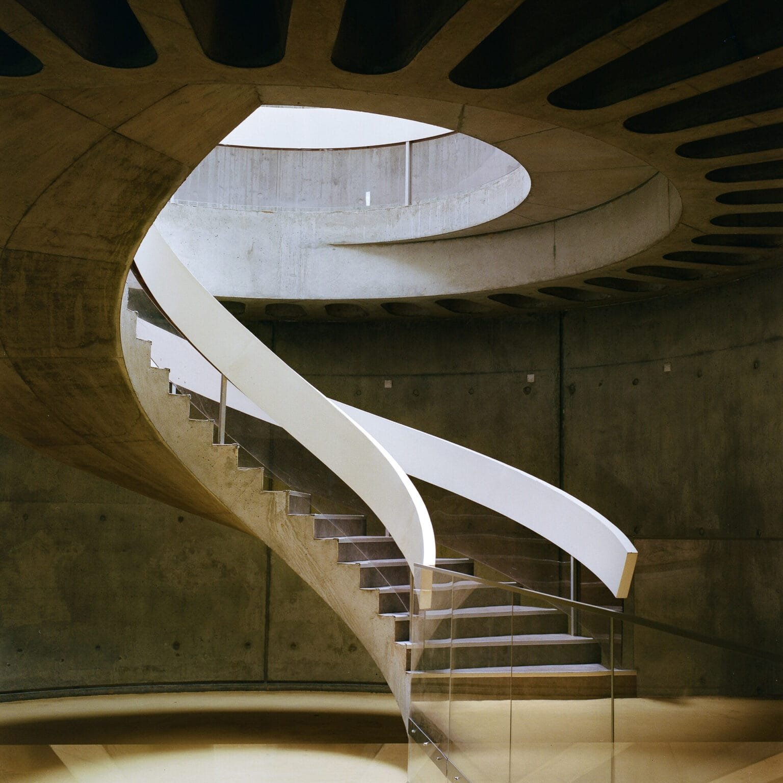 Escalier en spirale du musée Lugdunum à Lyon, en béton brut et rampe blanche, photographié avec un Hasselblad 500 C/M et une pellicule Portra 400.