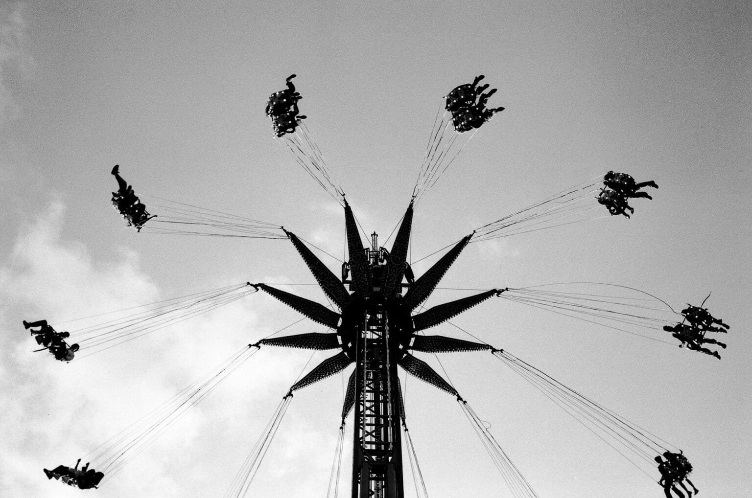Manège à balançoires en mouvement à la fête foraine de Nantes, photographié en noir et blanc.