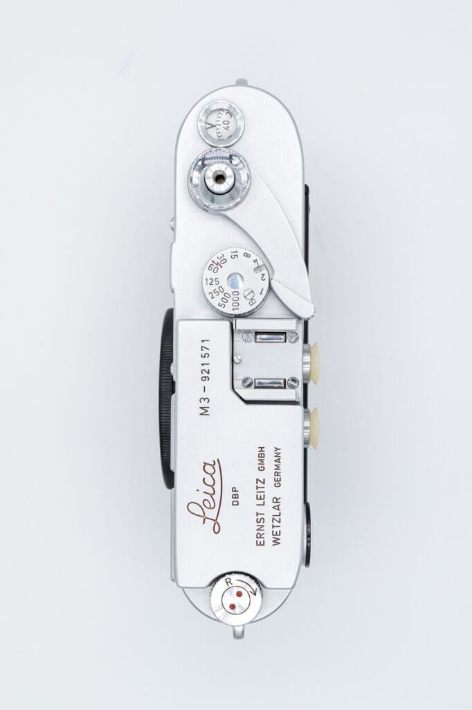 Vue de dessus du Leica M3, montrant la plaque supérieure avec la molette de sélection des vitesses, le levier d’armement et les gravures Leica.