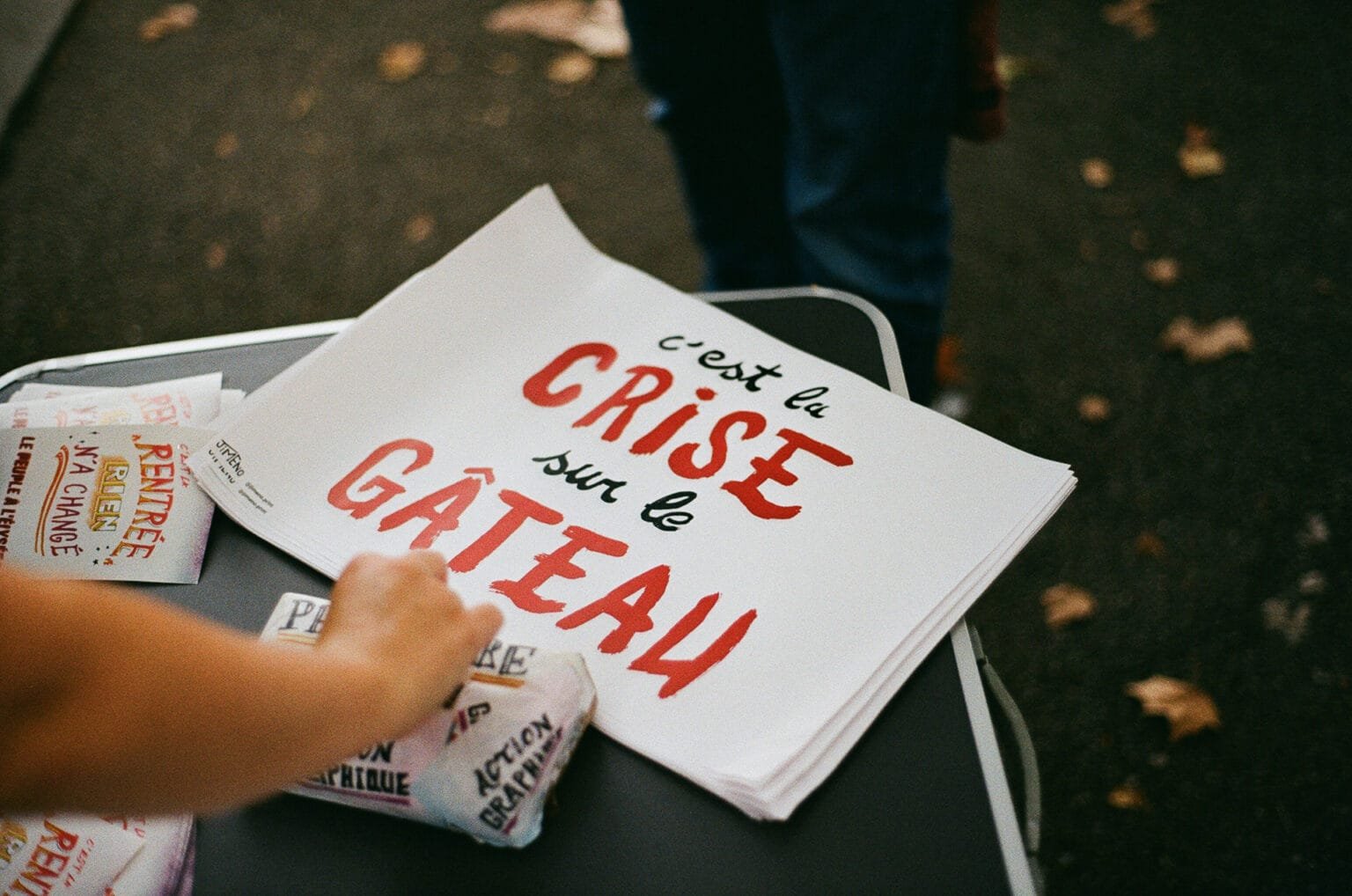 Affiche posée sur une table avec le slogan “C’est la crise sur le gâteau”, prise lors d’une manifestation à Nantes.