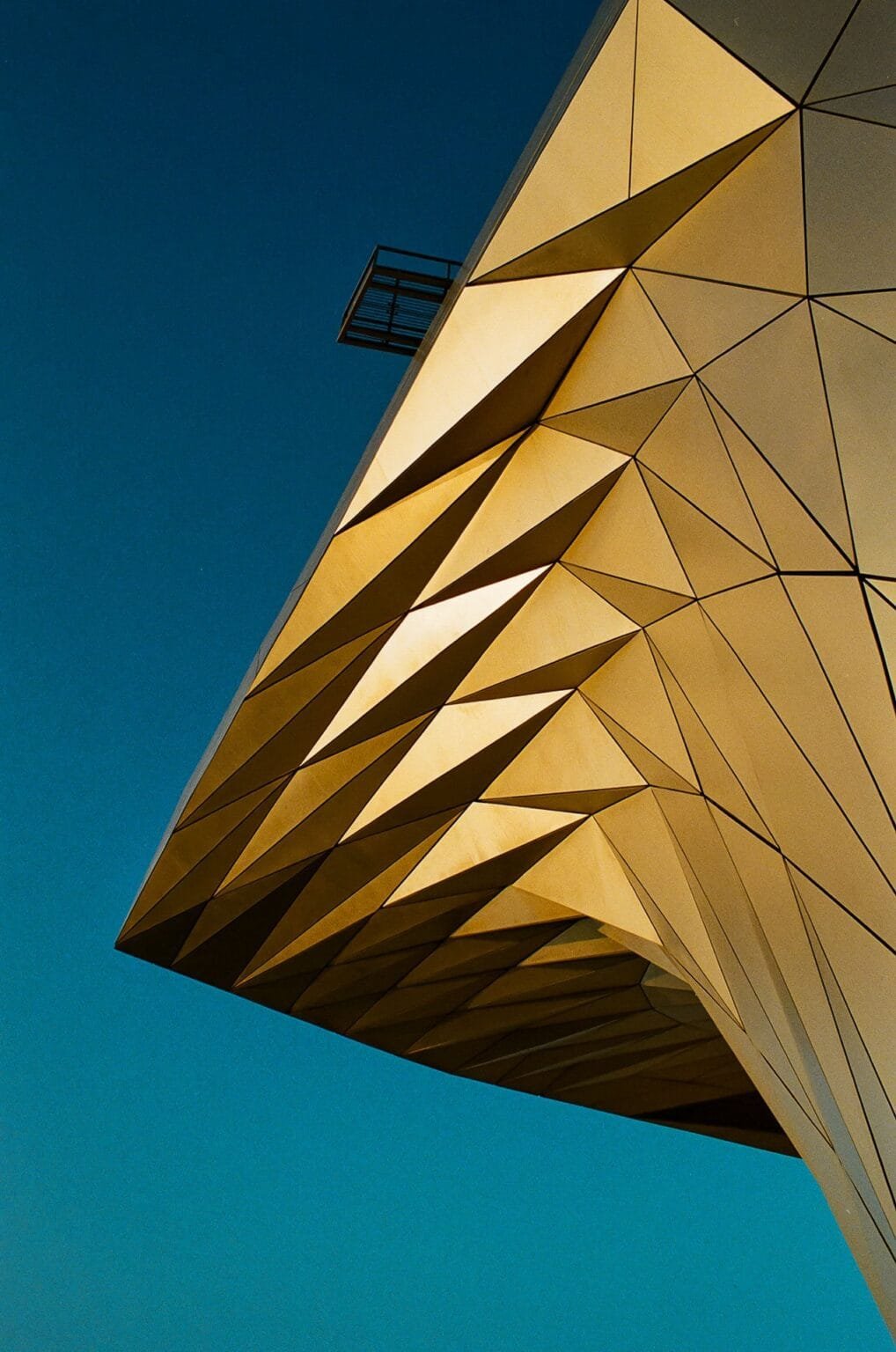 Structure géométrique dorée du Musée des Confluences à Lyon, photographiée en plongée avec un Nikon F3.