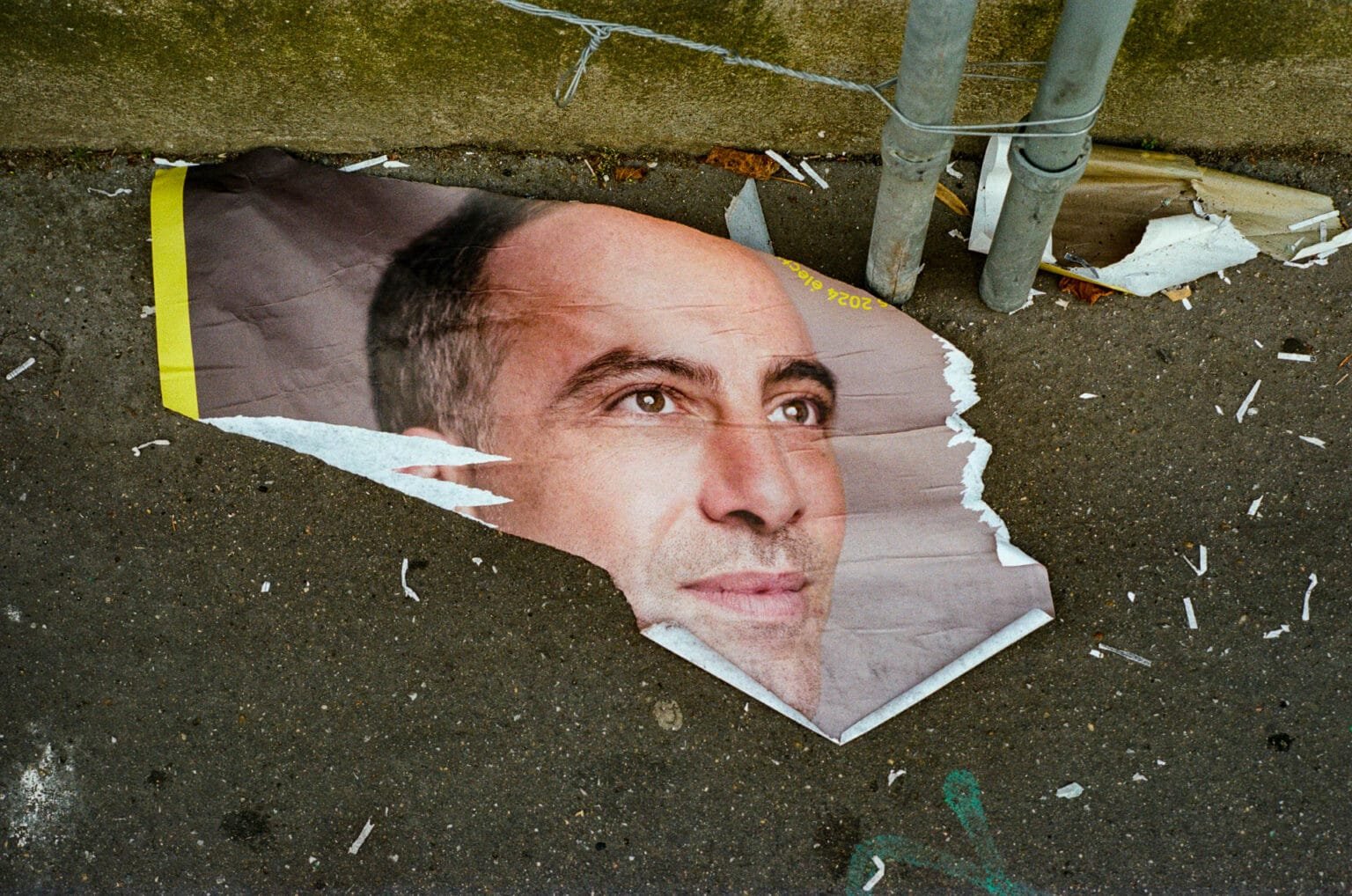 Affiche déchirée du candidat aux élections Raphael Glucksmann, au sol, dans une rue de Nantes.