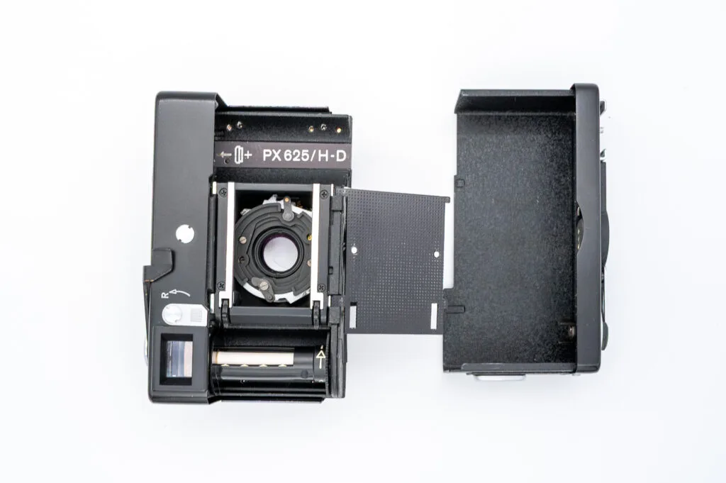 Vue de l’intérieur du Rollei 35 S avec le dos ouvert, montrant le compartiment à film, l’obturateur, et l’emplacement de la pile PX 625.