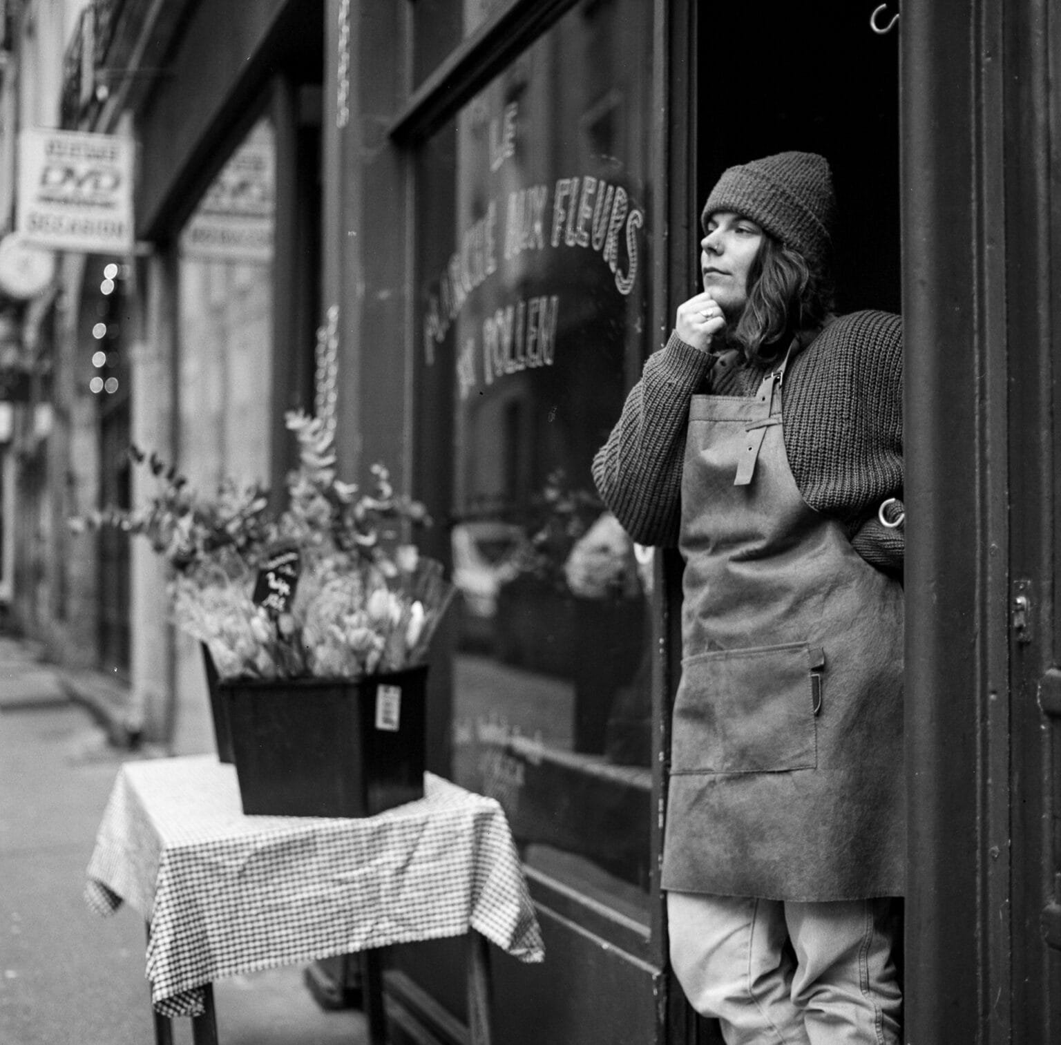 Portrait en noir et blanc d’une fleuriste devant sa boutique à Nantes, prise avec un Hasselblad 500 C/M.