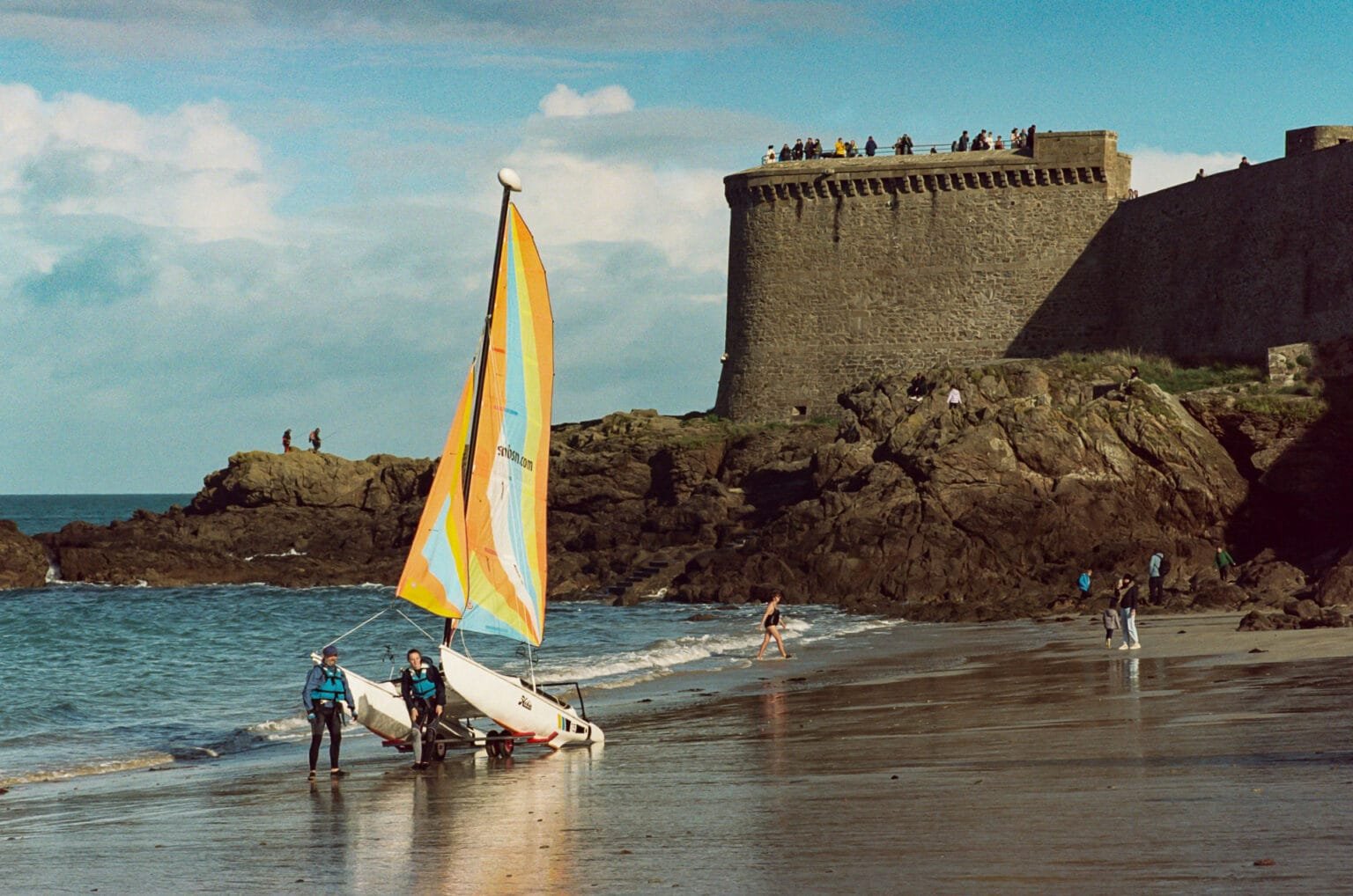 Voilier coloré sur la plage de Saint-Malo avec les remparts en arrière-plan, photographié en novembre.