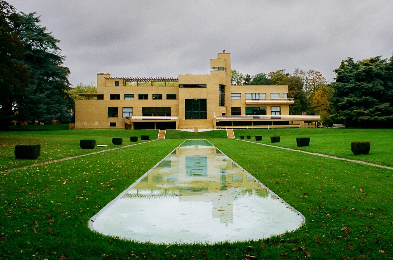 Façade principale de la Villa Cavrois à Croix, avec reflet dans le bassin central, sous un ciel nuageux.
