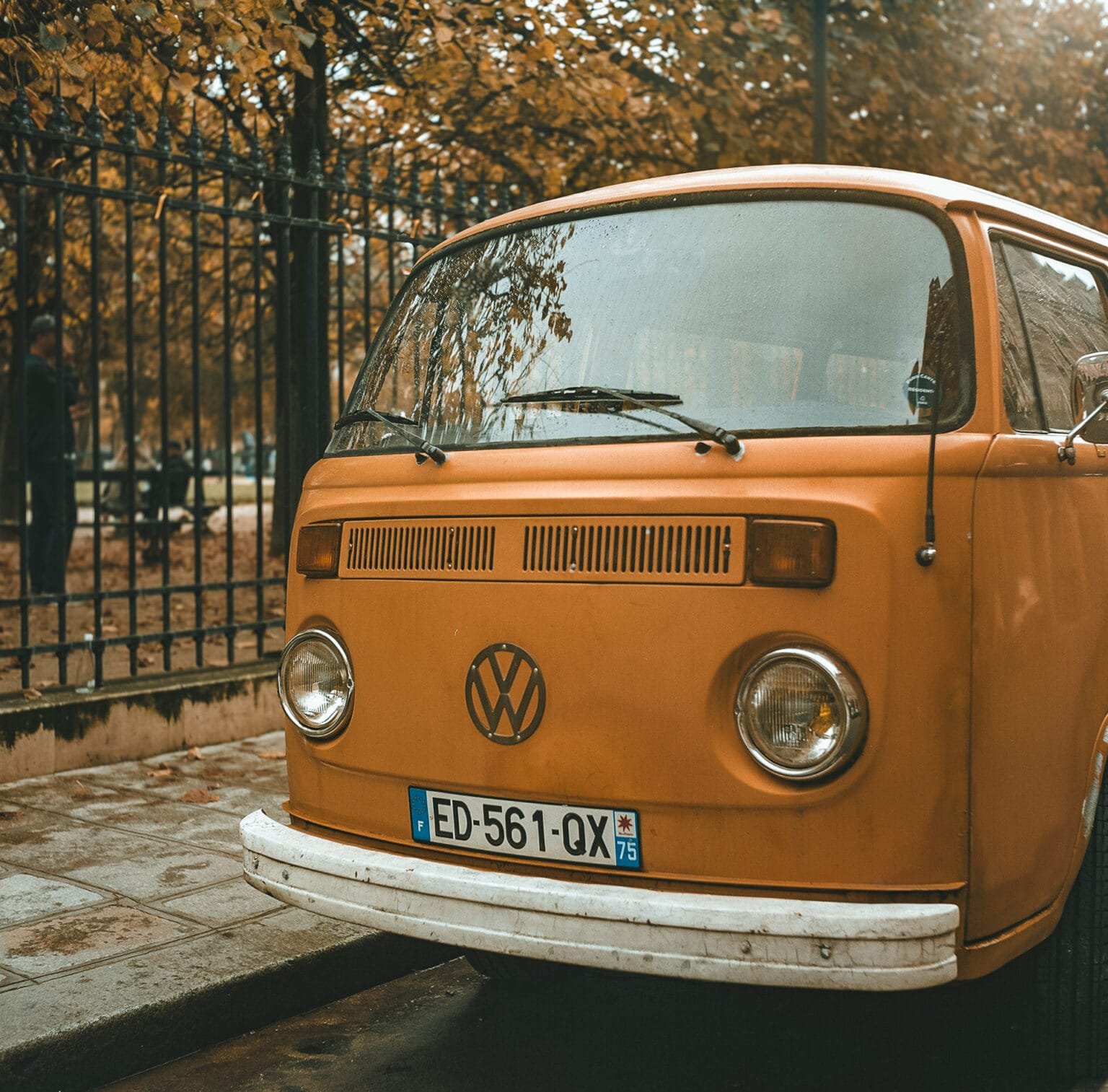 Volkswagen Combi orange garé sur une rue parisienne en automne, photographié avec un Yashica Mat 124G sur pellicule Kodak Portra 160.