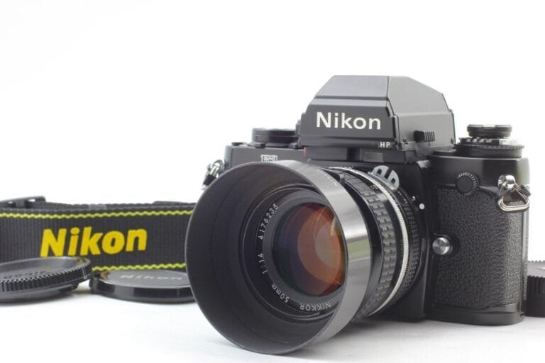 Boîtier Nikon F3 HP avec objectif Nikkor 50mm f/1.4 et pare-soleil, posé sur fond blanc