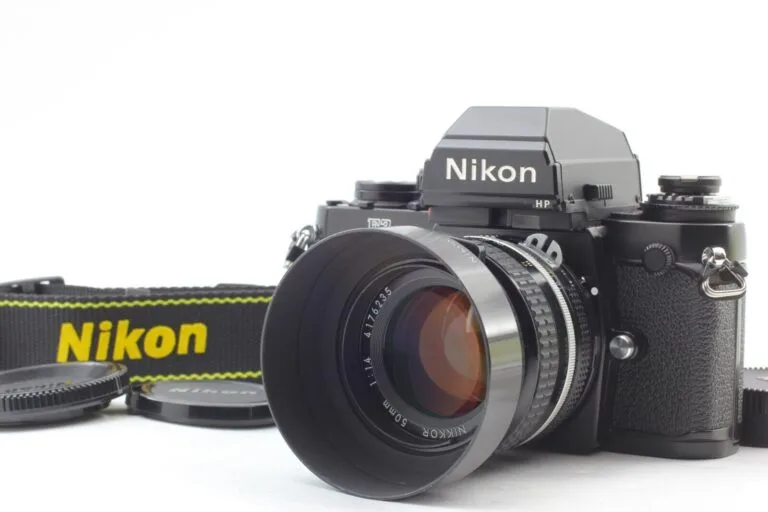 Boîtier Nikon F3 HP avec objectif Nikkor 50mm f/1.4 et pare-soleil, posé sur fond blanc