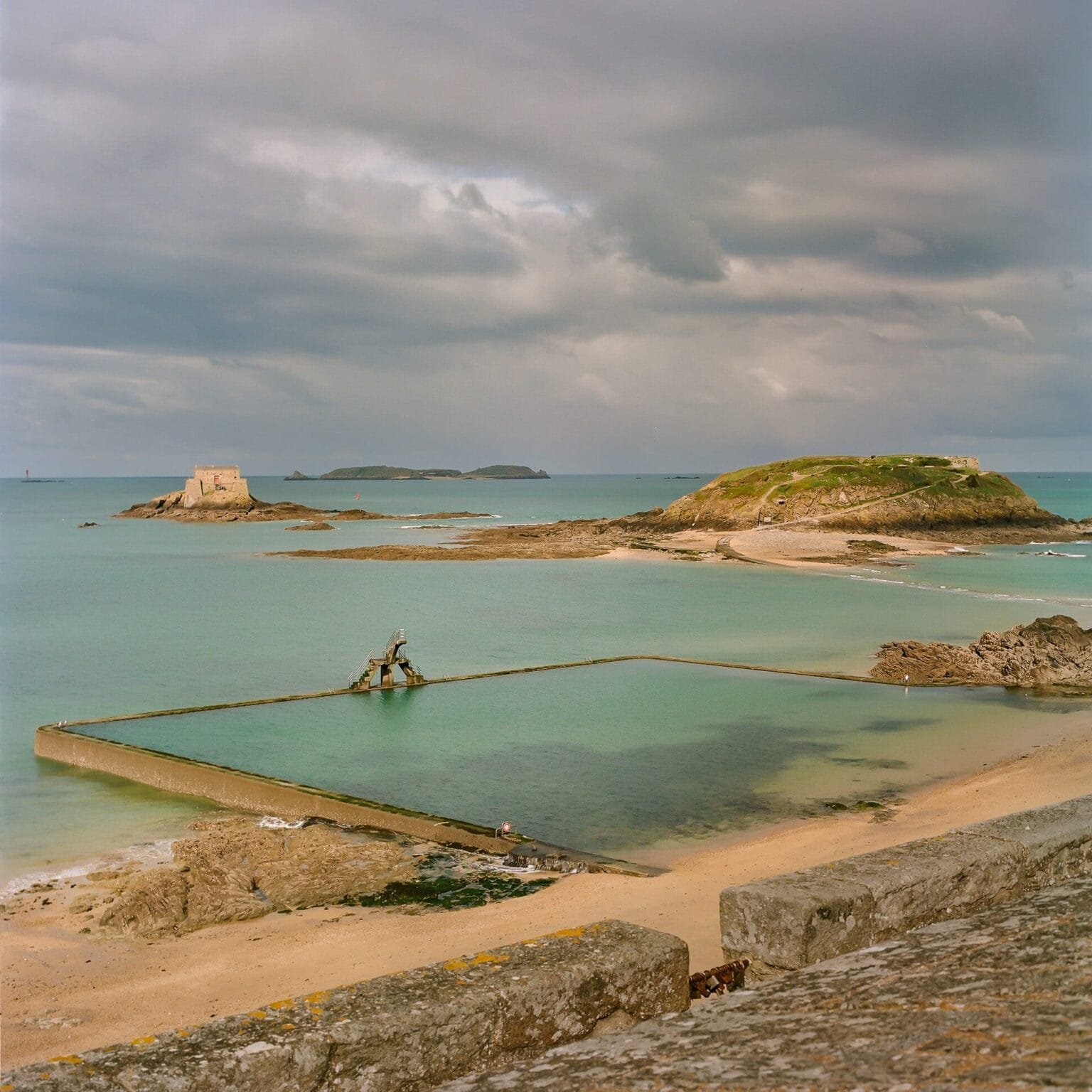 Vue de la piscine de Bon Secours à Saint-Malo avec l’île du Grand Bé en arrière-plan. Photographie prise avec un Hasselblad 500 C/M sur pellicule Portra 160.