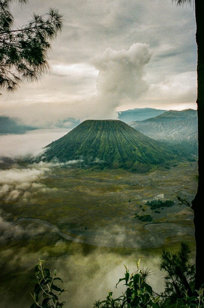 Le volcan Bromo au lever du jour, vu depuis King Kong Hill, entouré de brume et de nuages.