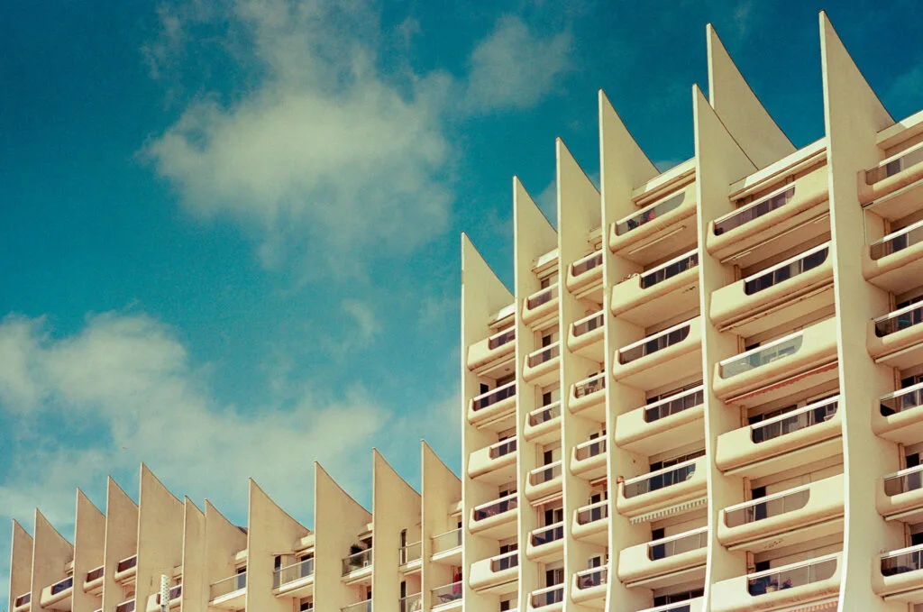 Façade moderniste des immeubles “Les Vagues” à La Baule sous un ciel bleu, capturée en couleur sur film.