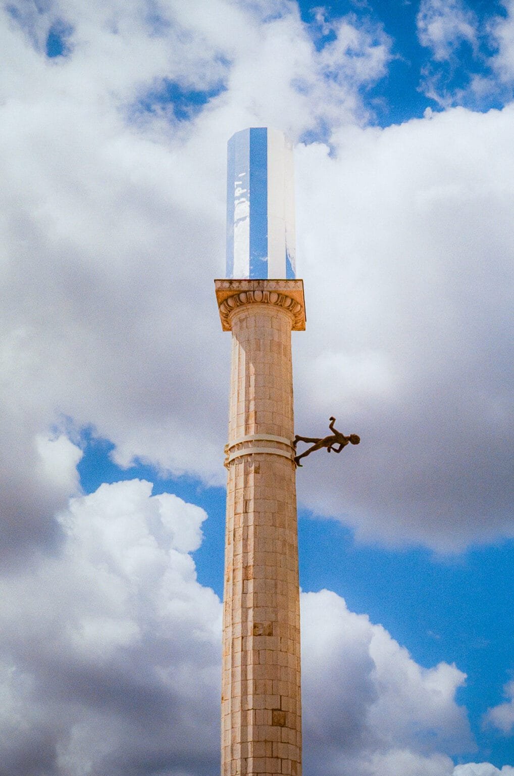 Sculpture Antipodos d’Iván Argote à Nantes, représentant un personnage suspendu à une colonne surmontée d’un miroir, photographiée en argentique.