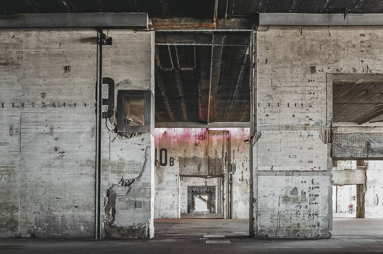 Vue en enfilade de plusieurs alvéoles en béton brut à la base sous-marine de Saint-Nazaire