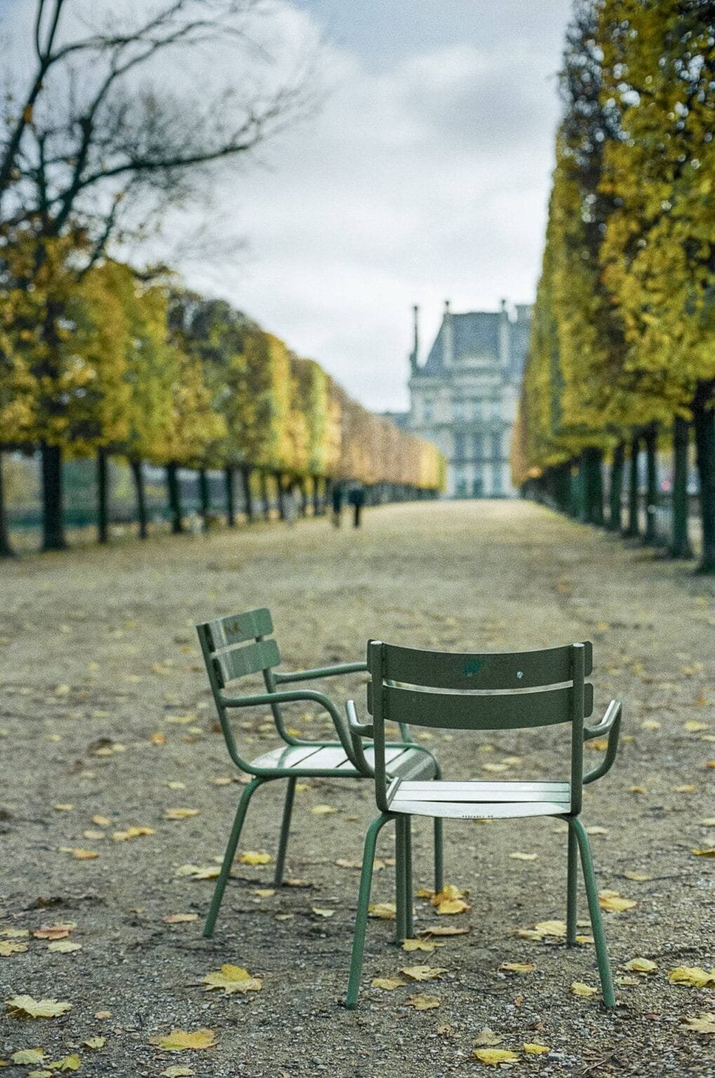 Deux chaises vertes vides dans l’allée centrale du jardin des Tuileries en automne, à Paris