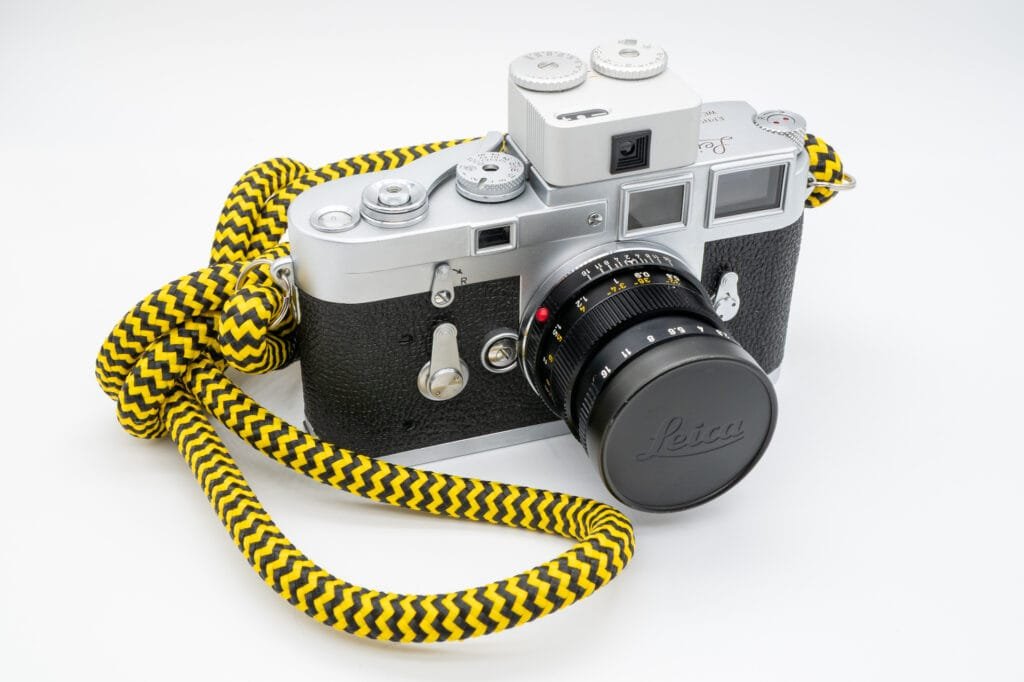 Leica M3 équipé de la cellule TT Artisan Meter II montée sur la griffe flash, avec objectif Summicron 50mm et dragonne jaune.