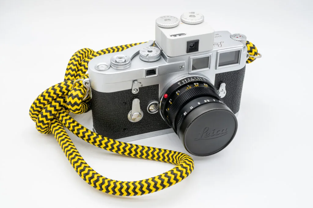 Leica M3 équipé de la cellule TT Artisan Meter II montée sur la griffe flash, avec objectif Summicron 50mm et dragonne jaune.