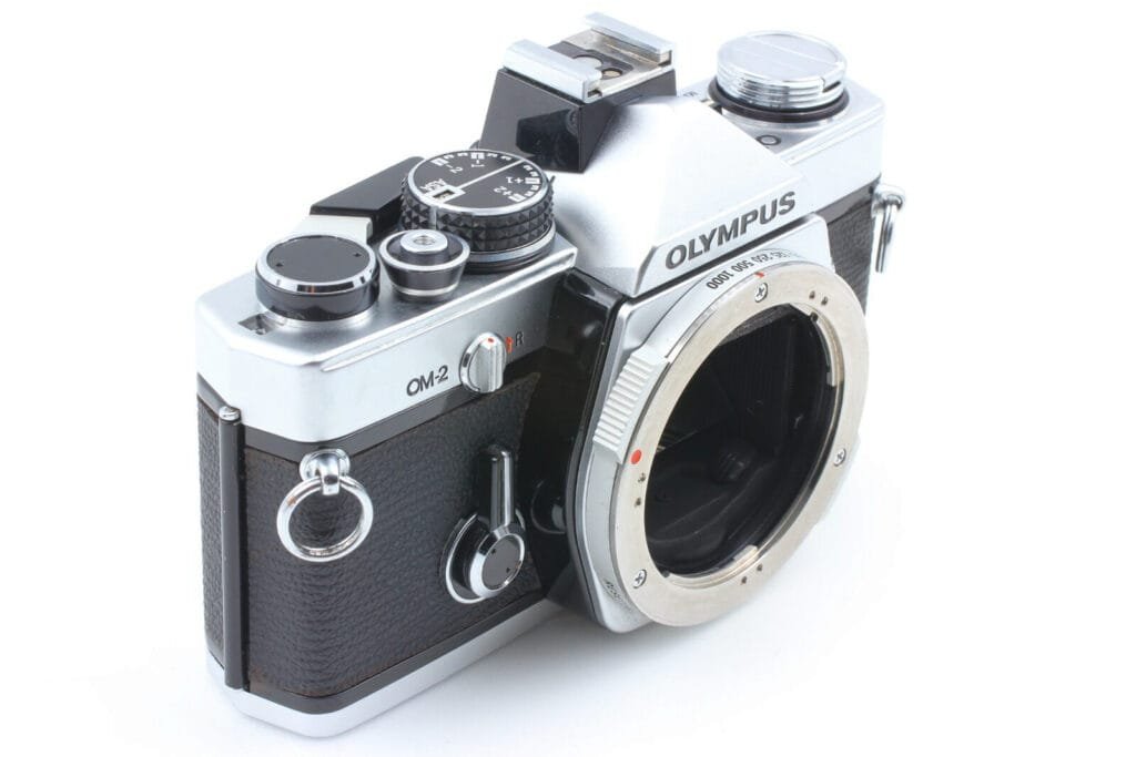 Vue de trois quarts de l’Olympus OM-2 avec la monture OM-System visible sans objectif.