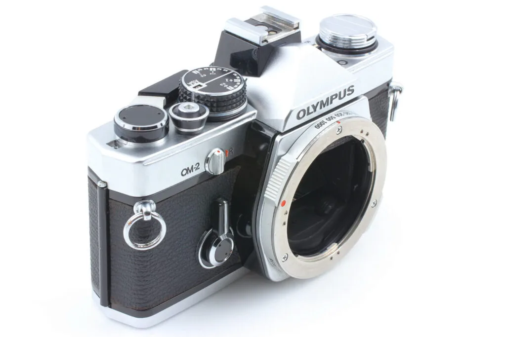 Vue de trois quarts de l’Olympus OM-2 avec la monture OM-System visible sans objectif.