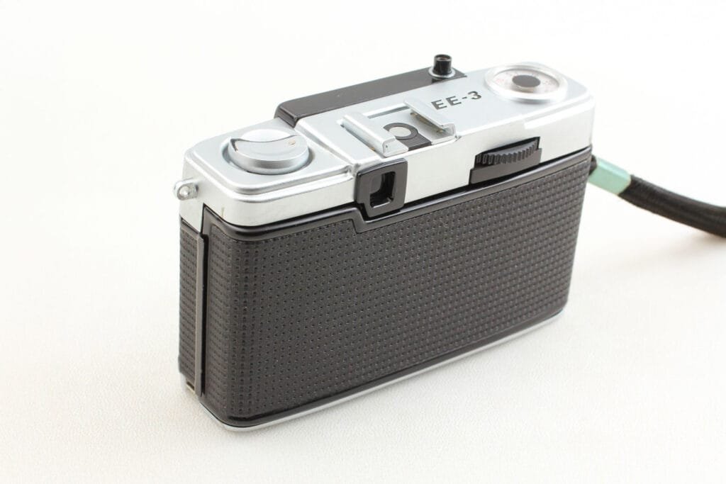 Vue arrière de l’Olympus Pen EE-3 montrant le levier d’armement et le viseur optique.