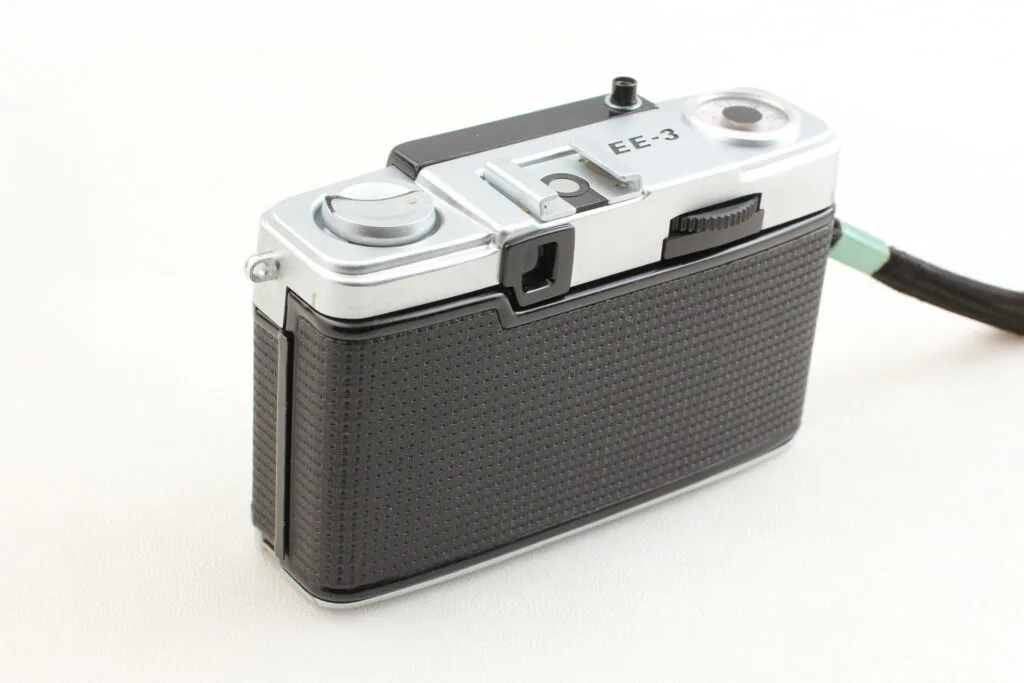 Vue arrière de l’Olympus Pen EE-3 montrant le levier d’armement et le viseur optique.
