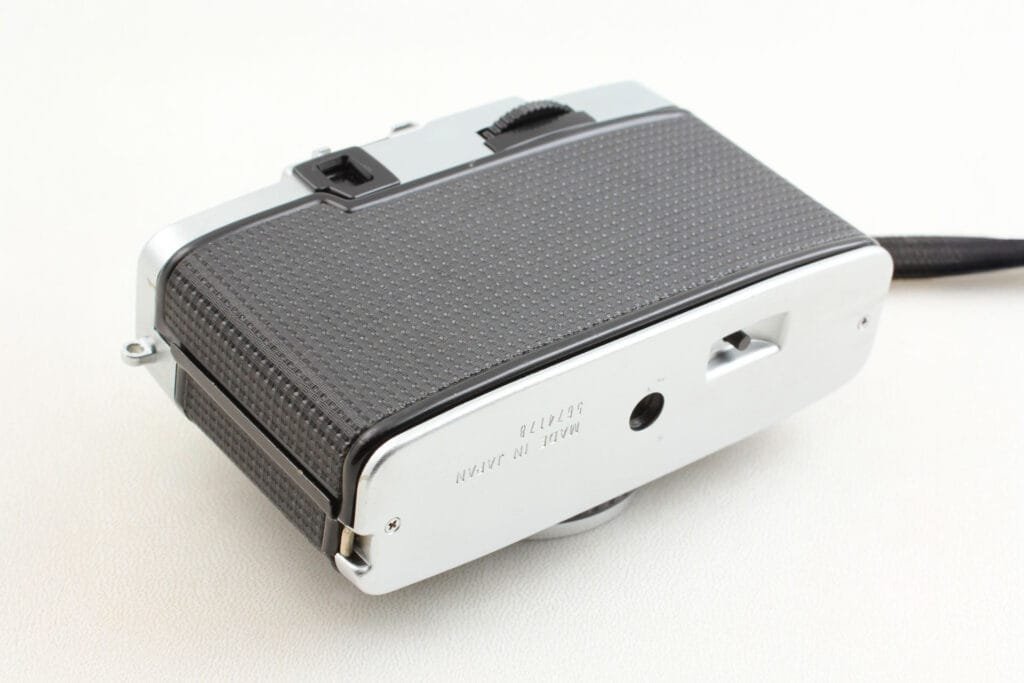 Vue du dessous de l’Olympus Pen EE-3 avec filetage trépied et mention « Made in Japan ».