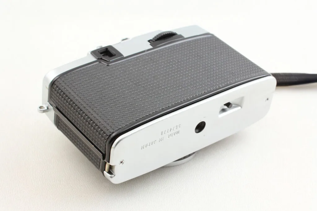Vue du dessous de l’Olympus Pen EE-3 avec filetage trépied et mention « Made in Japan ».