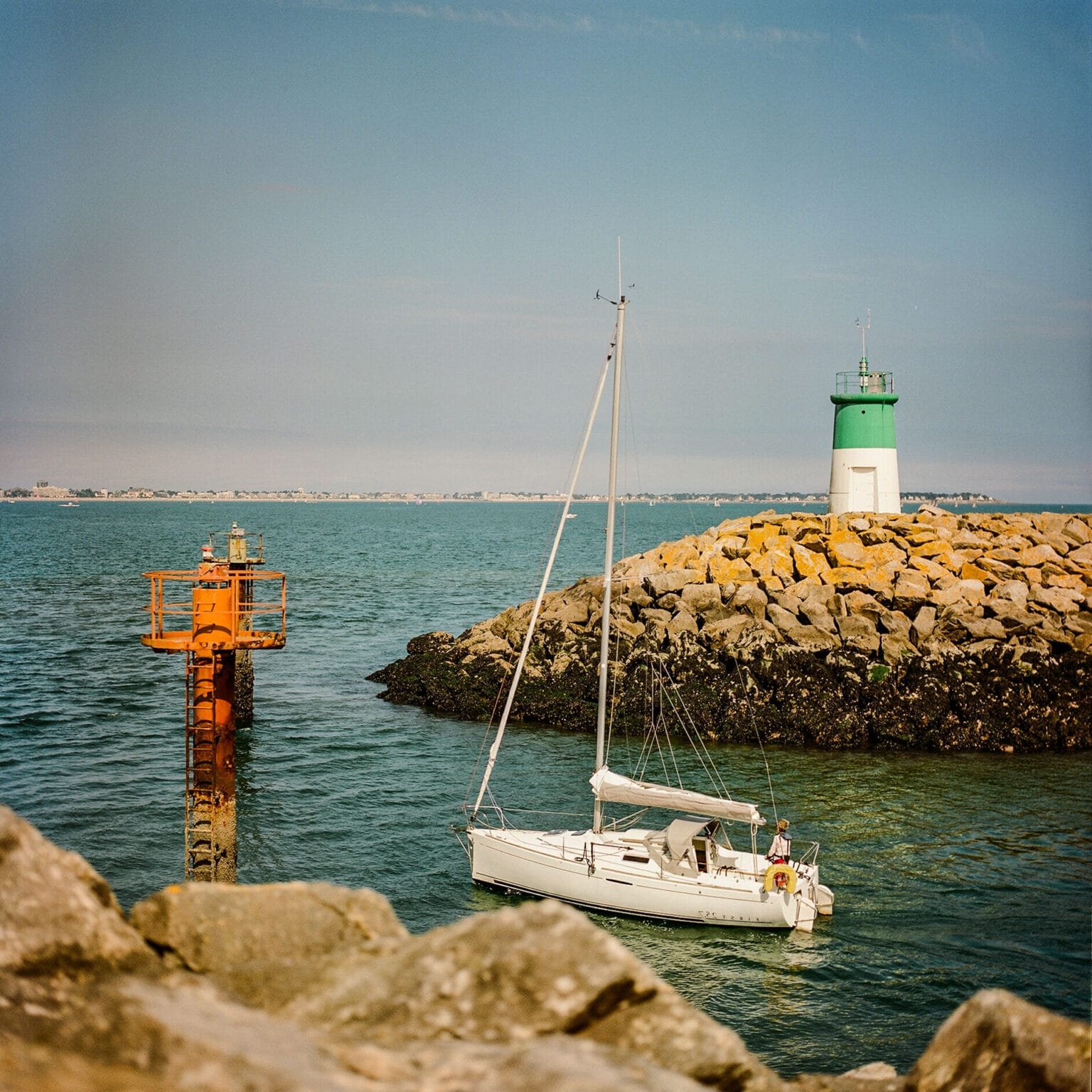 Voilier entrant dans le port de Pornichet, longeant le phare vert, photographié en couleur avec un Hasselblad 500 C/M.
