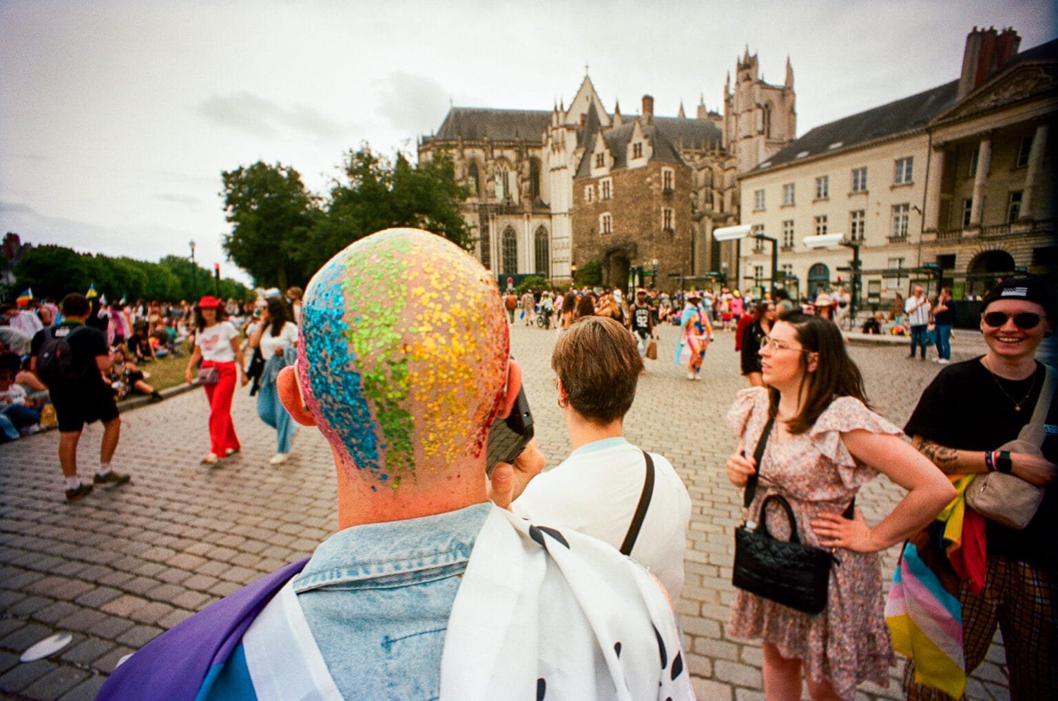 Participant avec le crâne recouvert de paillettes arc-en-ciel devant la cathédrale de Nantes.