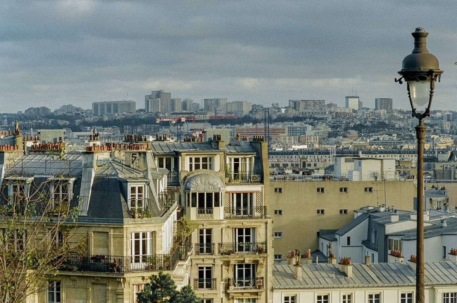 Vue depuis Montmartre sur les toits de Paris avec un lampadaire ancien au premier plan