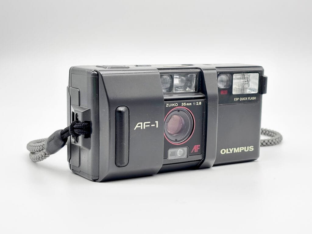 Olympus AF-1 avec le capot ouvert laissant apparaître l’objectif Zuiko 35 mm f/2.8.