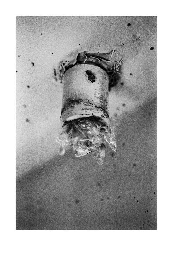 Ampoule cassée fixée au plafond du parking Gare Nord de Nantes, photographiée en noir et blanc avec un Nikon F3 HP.