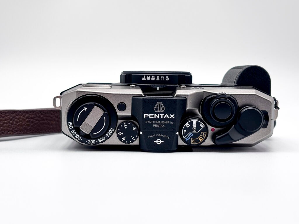 Vue du dessus du Pentax 17 montrant les molettes ISO, modes de prise de vue et levier d’armement.