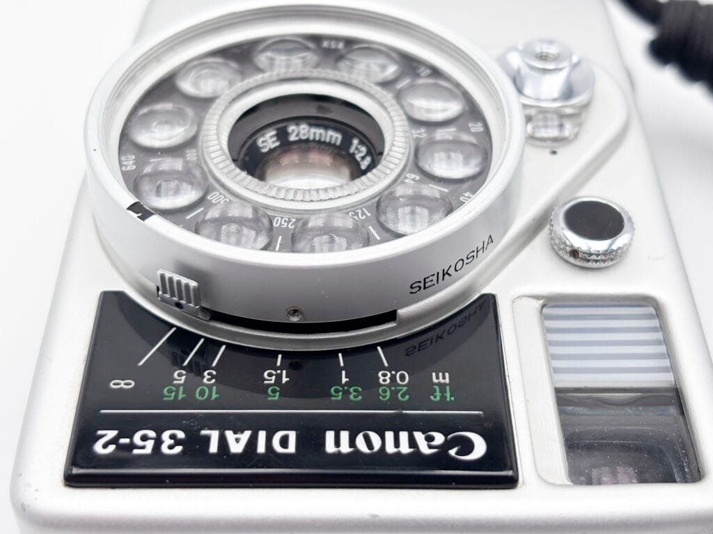 Gros plan sur l’objectif Canon 28mm f/2.8 du Dial 35-2 et l’échelle de mise au point.