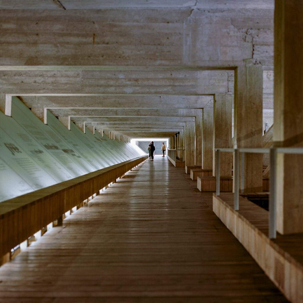 Deux personnes marchent dans la galerie centrale en béton du Mémorial de l’abolition de l’esclavage à Nantes