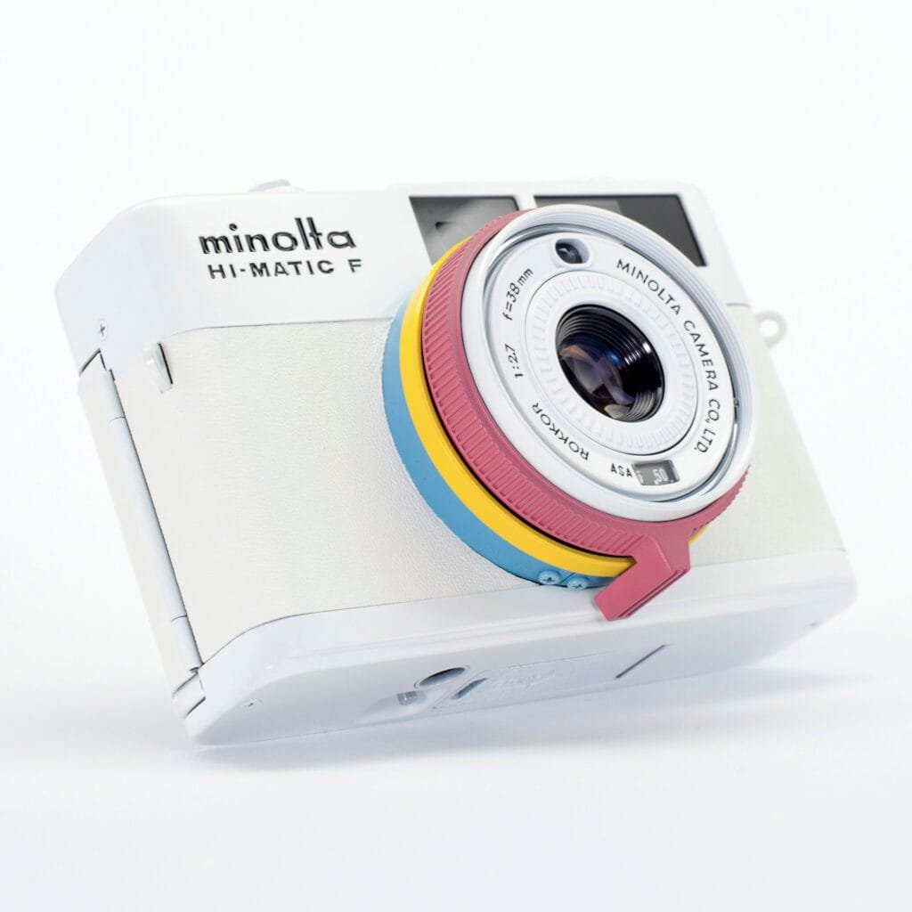 Minolta Hi-Matic F revisité par Eye Out Camera, finition blanche et anneaux colorés pastel, boîtier compact télémétrique des années 70.
