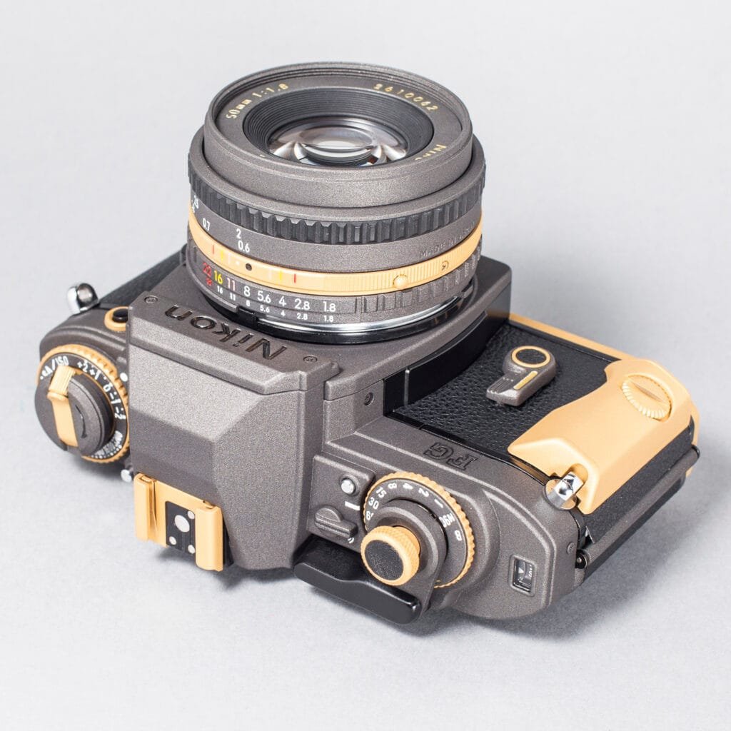 Nikon FG revisité par Eye Out Camera, finition bicolore bronze et or, objectif 50 mm f/1.8 monté.