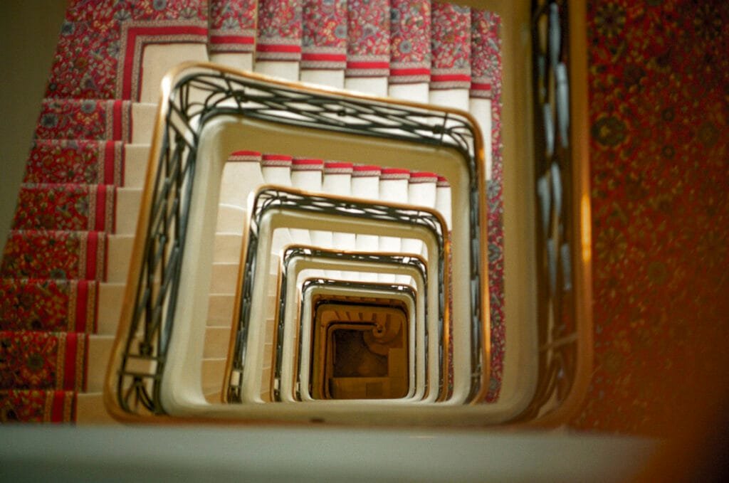 Escalier en spirale vu en plongée à l’Hôtel Royal de Deauville, photographié en argentique.