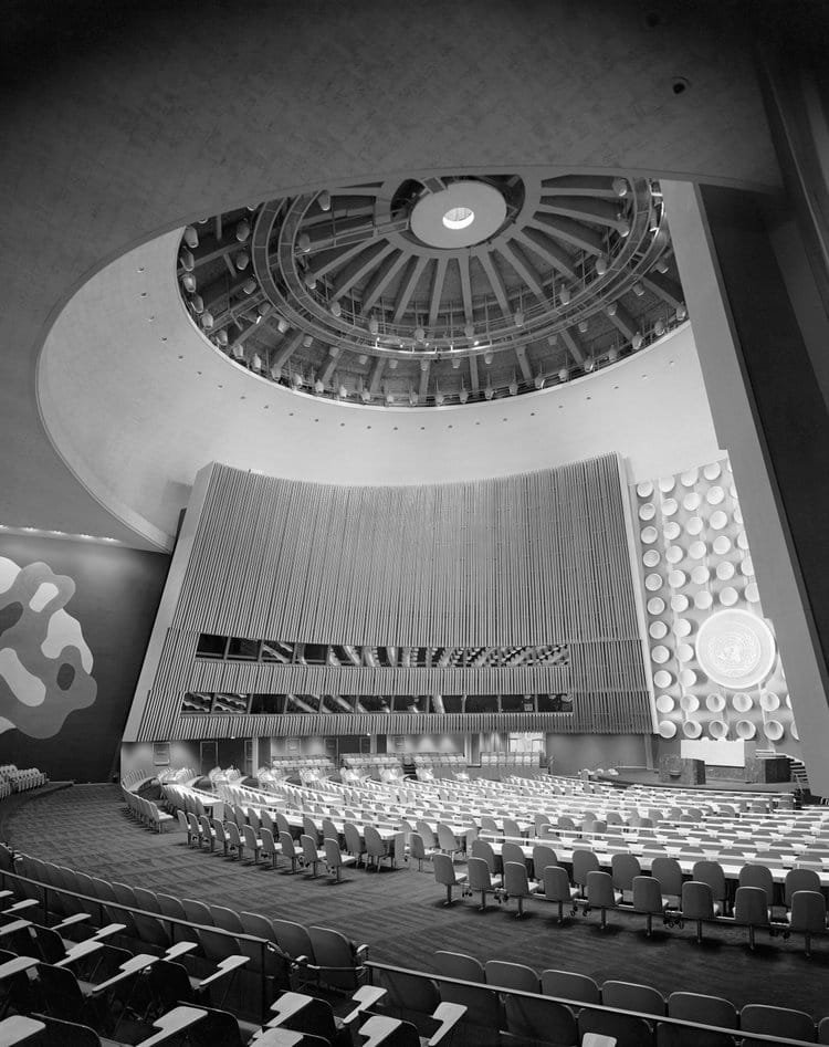 Vue intérieure de la salle de l’Assemblée générale des Nations unies à New York, photographiée en 1953 par Ezra Stoller, montrant l’architecture moderniste et la coupole centrale.