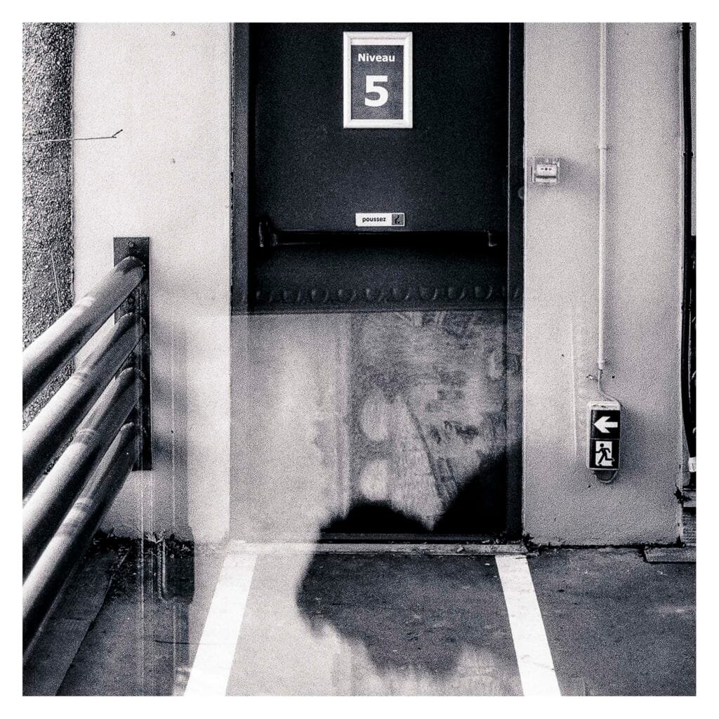 Porte “Niveau 5” du parking superposée à une silhouette issue du Musée d’Art dans une double exposition réalisée au Nikon F3 sur film Fomapan 400.