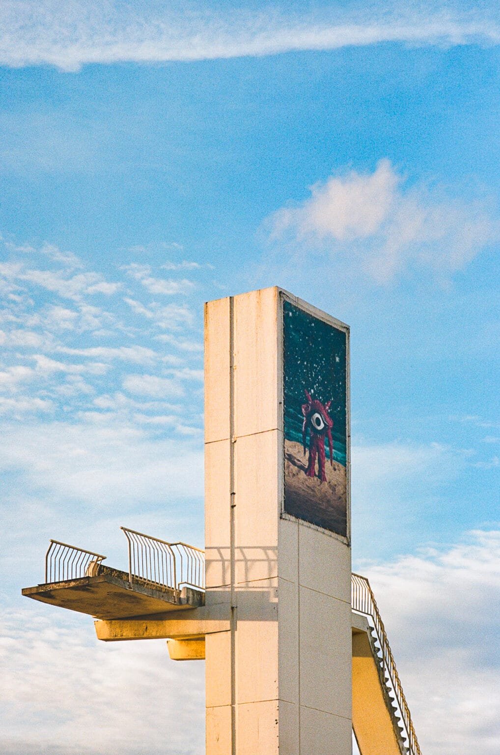 Plongeoir extérieur de la piscine de Deauville avec fresque, photographié en fin de journée.