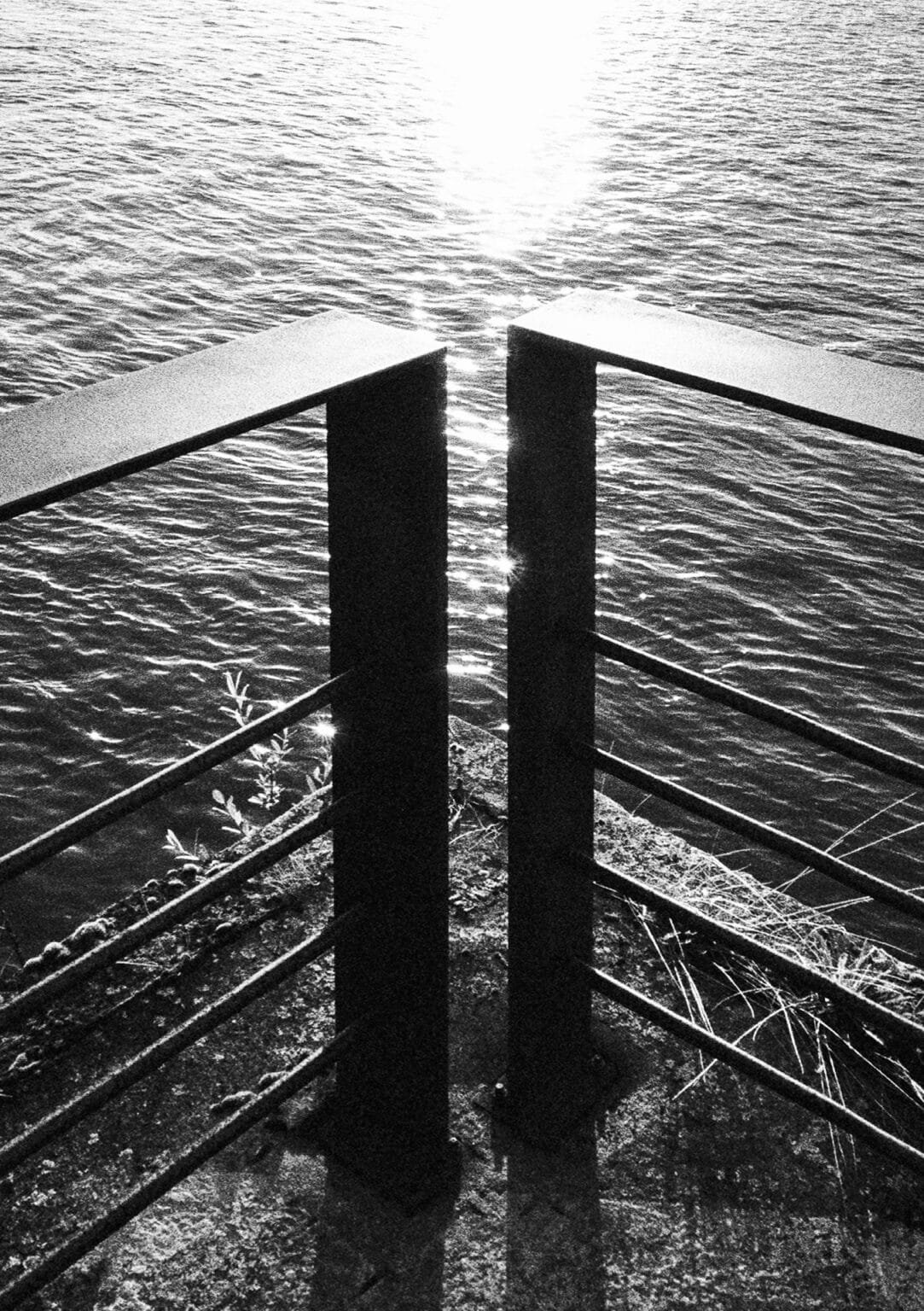 Soleil rasant sur les quais de la Loire, cadré entre deux poteaux métalliques en contre-jour.