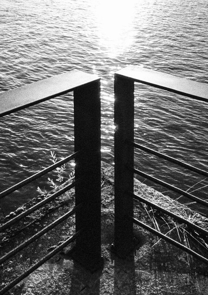 Soleil rasant sur les quais de la Loire, cadré entre deux poteaux métalliques en contre-jour.