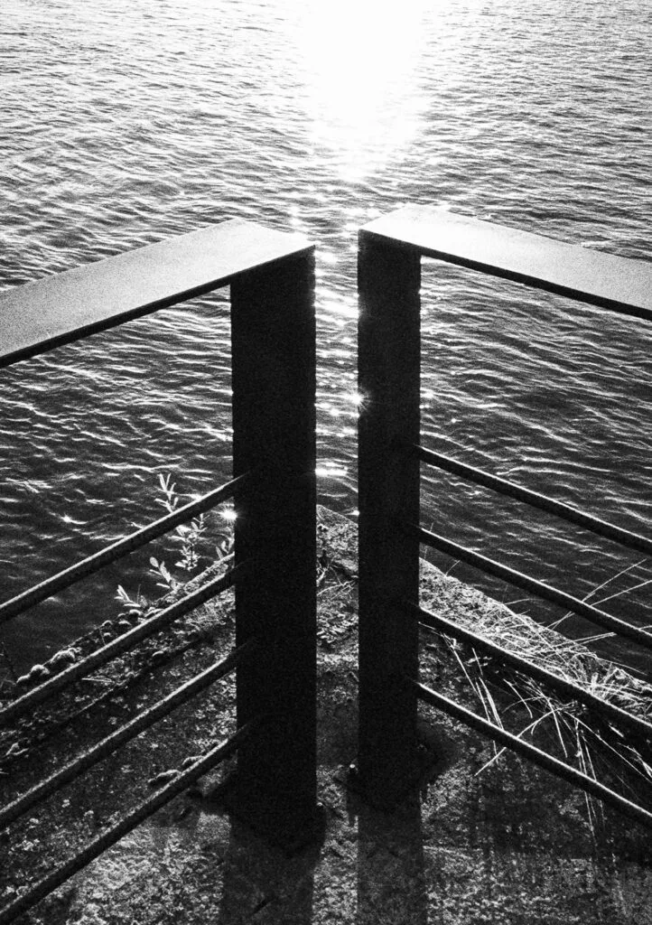 Soleil rasant sur les quais de la Loire, cadré entre deux poteaux métalliques en contre-jour.