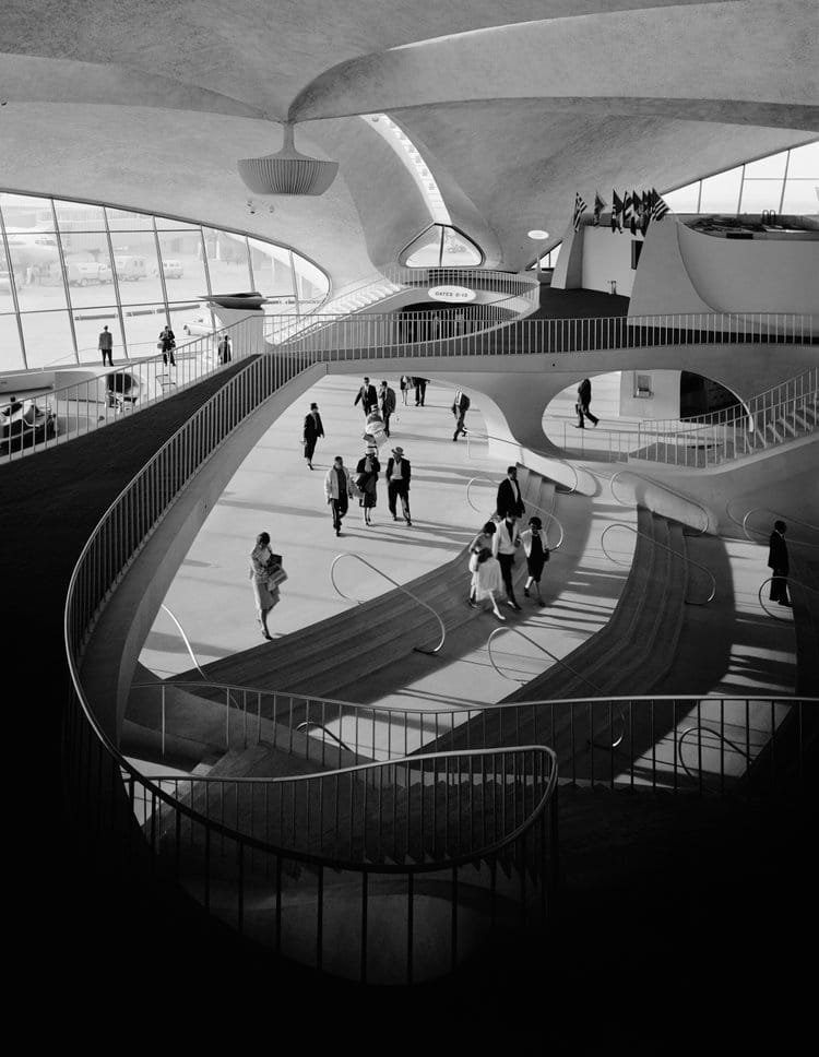 Vue intérieure du hall principal du TWA Flight Center à New York, photographié en 1962 par Ezra Stoller, avec voyageurs et architecture organique d’Eero Saarinen.