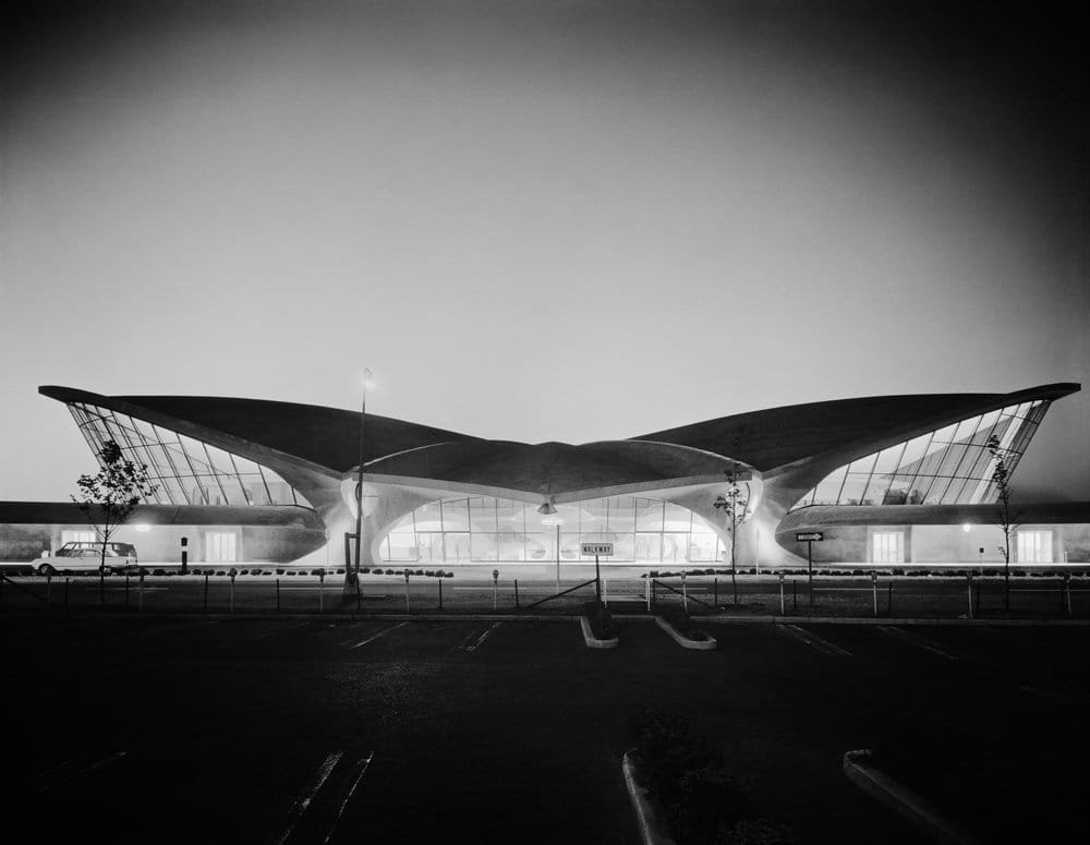 Vue nocturne du TWA Flight Center à New York photographiée en 1962 par Ezra Stoller, montrant la silhouette en aile du terminal conçu par Eero Saarinen.