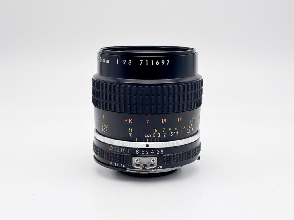 Objectif Nikon Micro-Nikkor 55mm f/2.8 vu de face sur fond clair