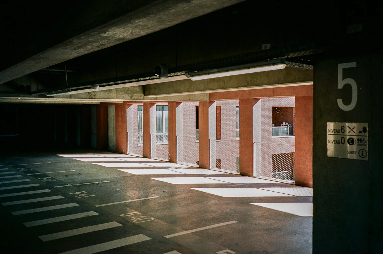 Lumière du soleil entrant dans le parking Gare Sud à Nantes, créant des bandes lumineuses sur le sol.